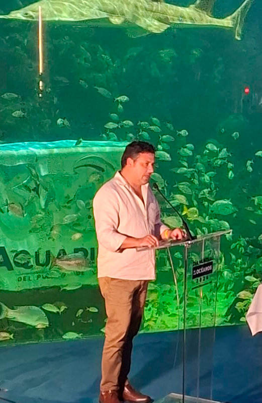 persona exponiendo con acuario de fondo